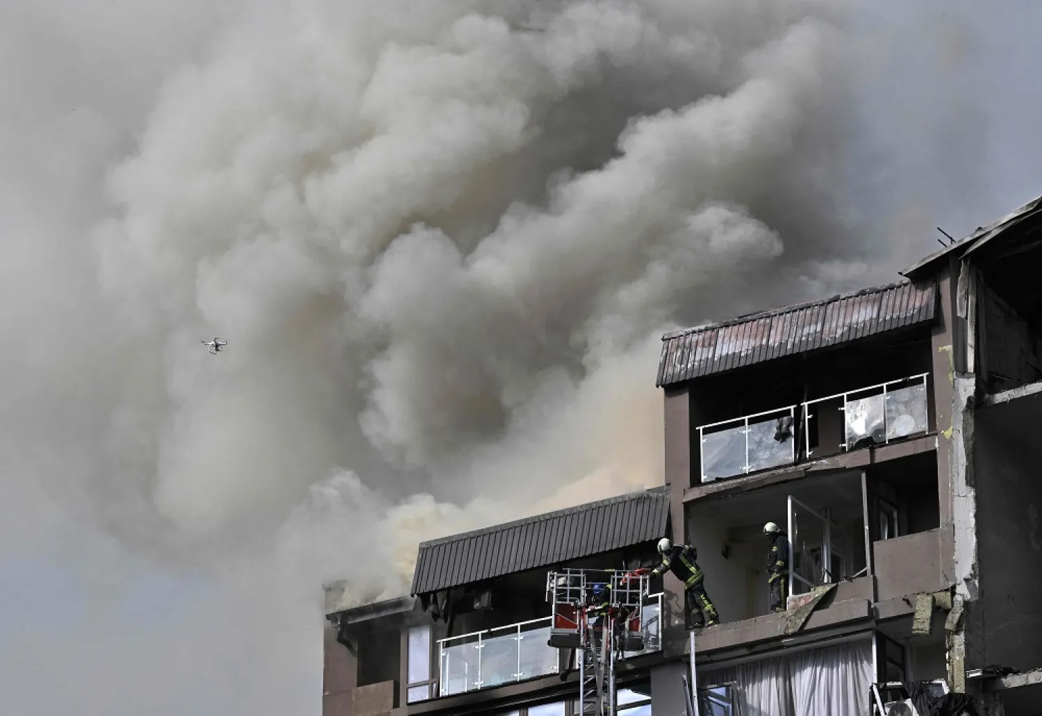 Rescuers and firefighters work in a damaged residential building, hit by Russian missiles in Kyiv on June 26, 2022, amid Russian invasion of Ukraine. (AFP)