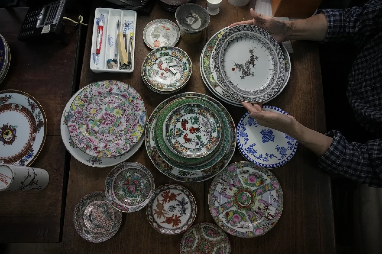 Joseph Tso, owner of Yuet Tung China Works, Hong Kong's porcelain factory, holds a plate with dragon print in Hong Kong, Wednesday, June 8, 2022. (AP)