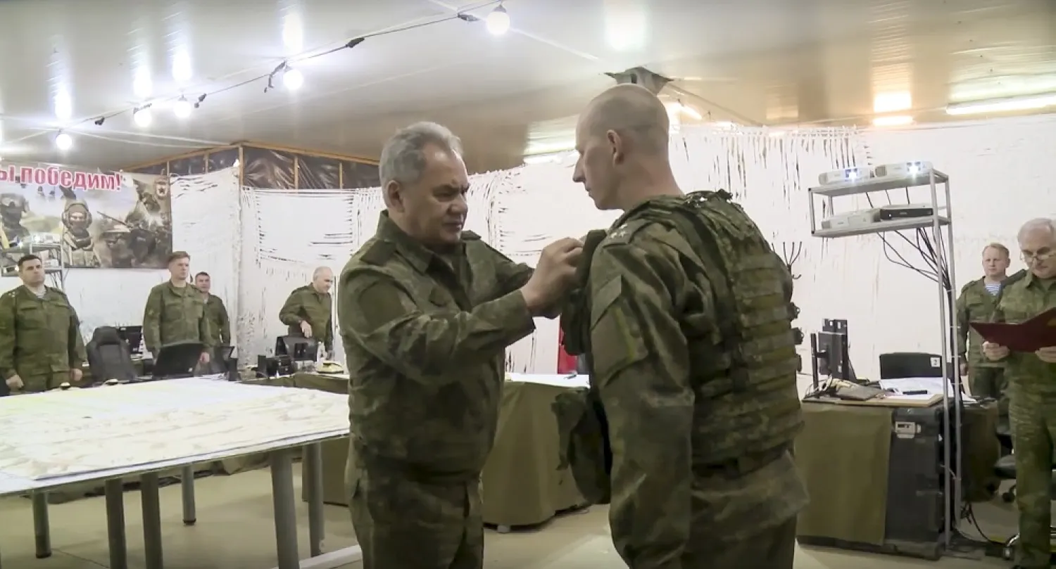In this image taken from video released by Russian Defense Ministry Press Service on Sunday, June 26, 2022, Russian Defense Minister Sergei Shoigu, foreground left, awards a Russian serviceman while inspecting the Russian troops participating in a special military operation in Ukraine. (Russian Defense Ministry Press Service via AP) 