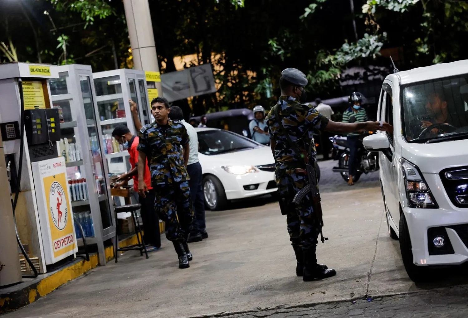 A Sri Lanka Air Force member checks the tokens of people queuing for fuel due to fuel shortage, amid the country's economic crisis, in Colombo, Sri Lanka, June 27, 2022. (Reuters)