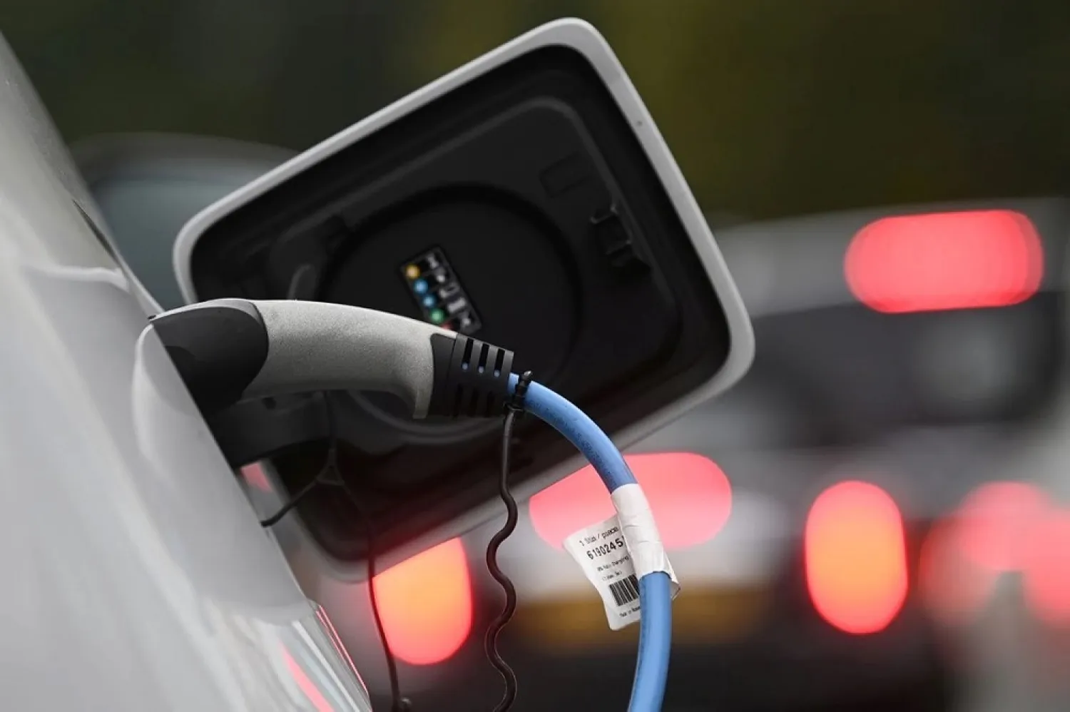 An electric car is charged at a roadside EV charge point, London, October 19, 2021. (Reuters)