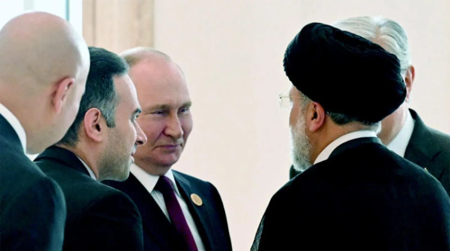 الرئيس الروسي فلاديمير بوتين ونظيره الإيراني إبراهيم رئيسي يتحدثان على هامش قمة بحر قزوين في عشق آباد أمس (رويترز)