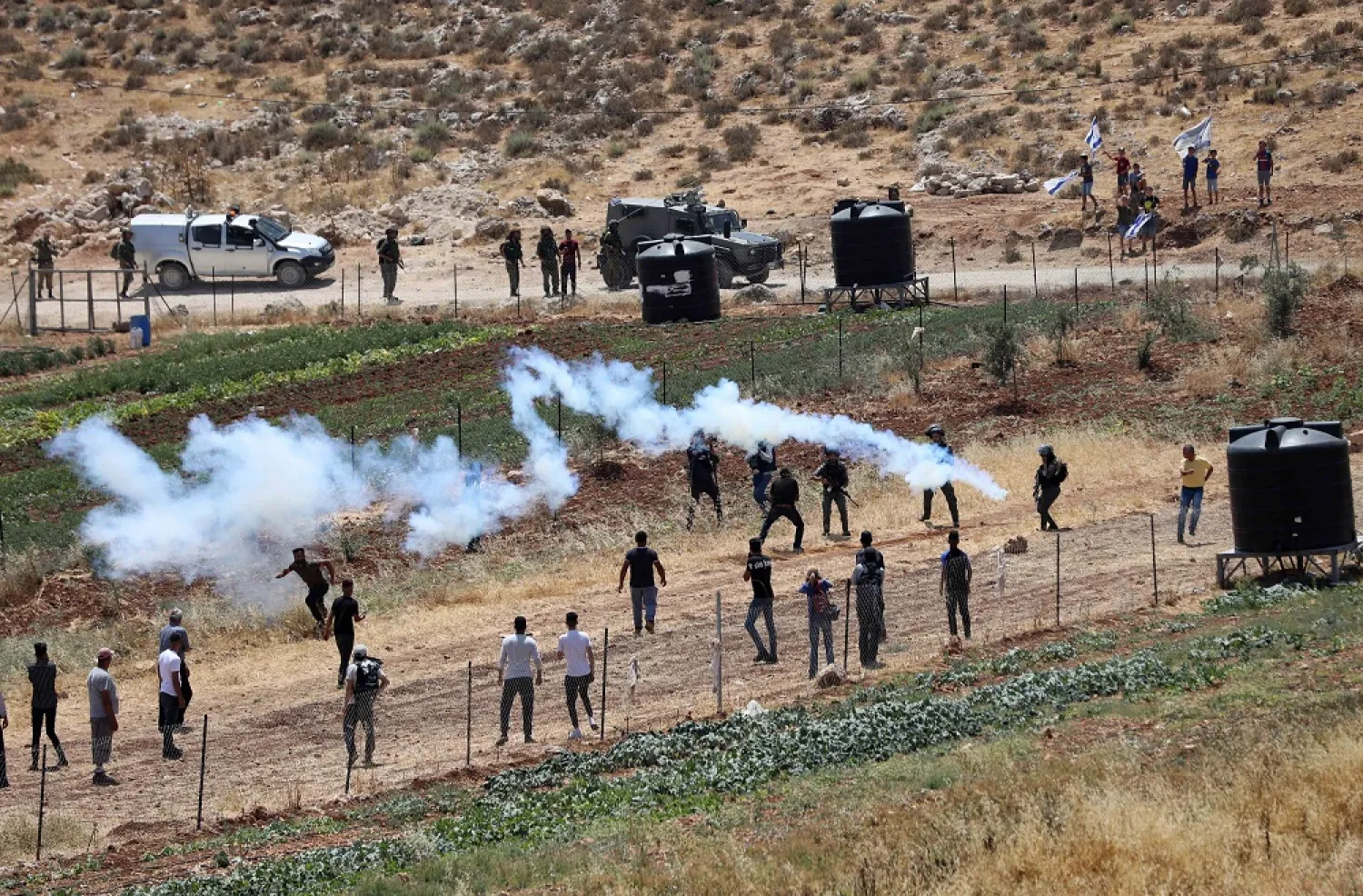 24 June 2022, Palestinian Territories, Nablus: Israeli security forces fire tear gas on Palestinian demonstrators during a protest against attempts by Israeli settlers from the settlement of Eli to take control of a water spring, in the village of Qaryut, near the West Bank City of Nablus. (dpa)