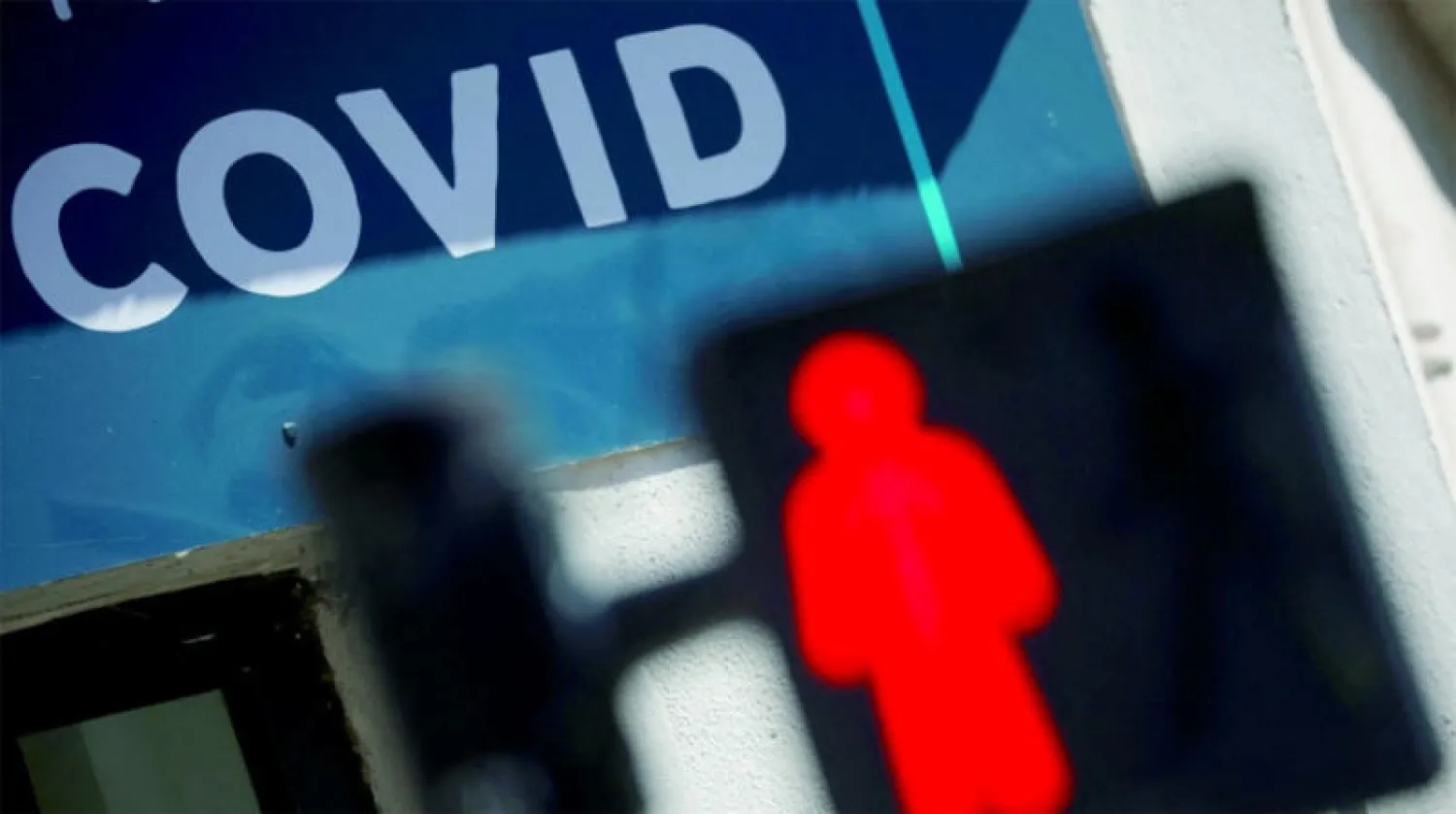 إشارة مرور أمام مركز اختبار فيروس «كورونا» بالقرب من نانت غرب فرنسا أمس (رويترز)