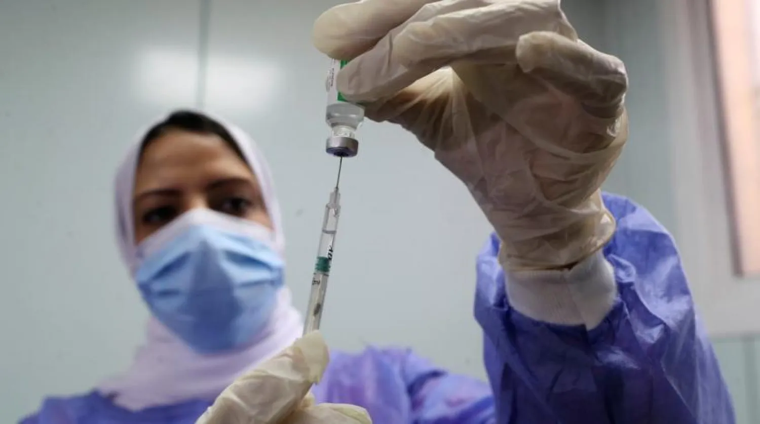 FILE PHOTO: A healthcare worker holds a syringe and vaccine vial against the coronavirus disease (COVID-19) in Cairo, Egypt March 4, 2021. REUTERS/Mohamed Abd El Ghany/File Photo
