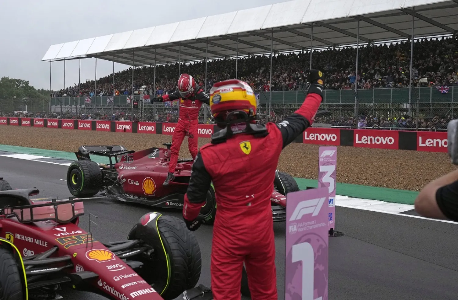 Spanish Formula One driver Carlos Sainz (front) of Scuderia Ferrari celebrates with his third placed teammate Charles Leclerc (back) of Monaco after taking the pole position following the qualifying session of the Formula One Grand Prix of Britain at the Silverstone Circuit, Silverstone, Britain, 02 July 2022. (EPA)