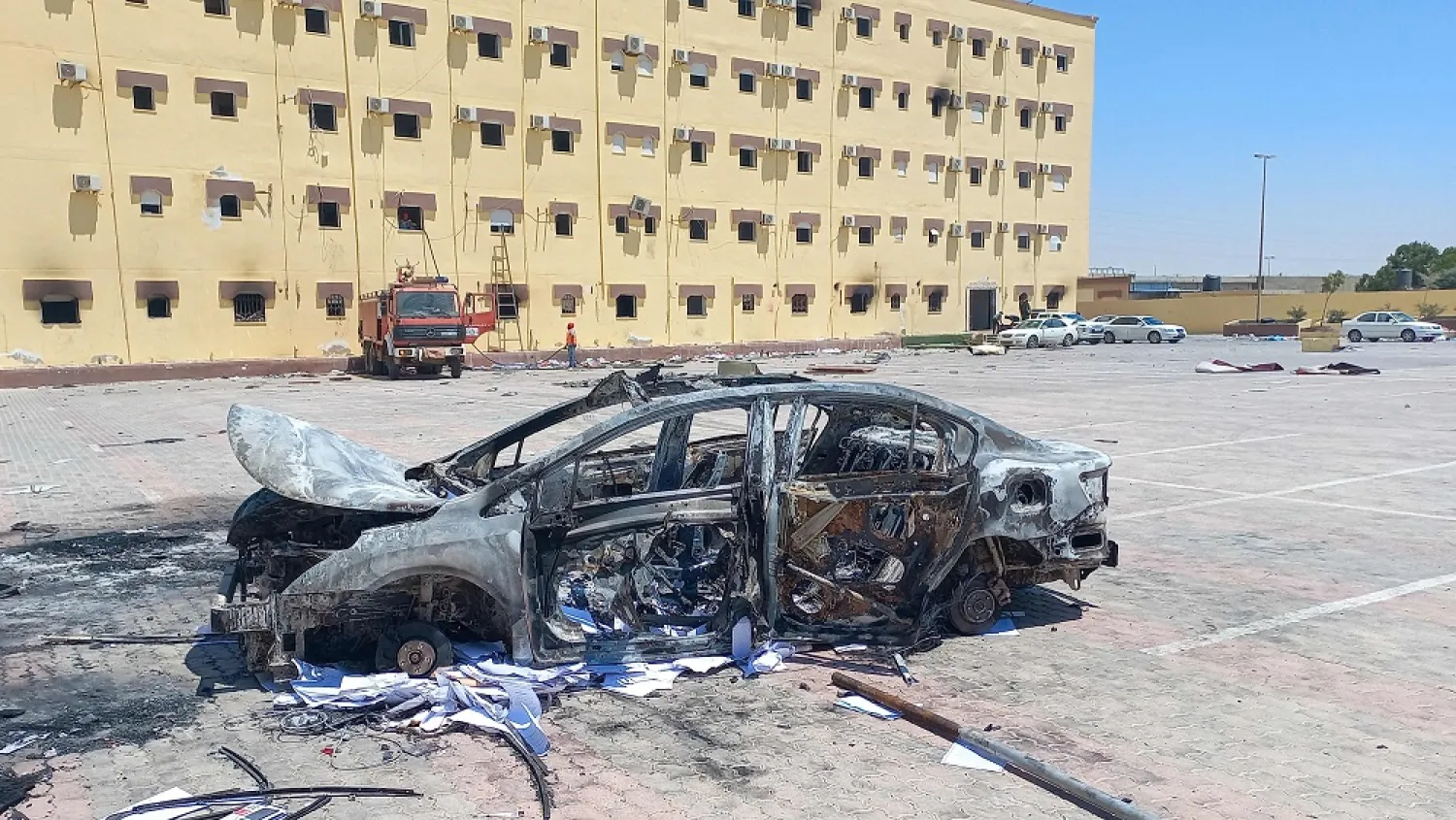 A picture shows a burnt vehicle outside the House of Representatives in the eastern city of Tobruk on July 2, 2022, after angry protesters stormed the building ransacking its offices and torching part of it. (AFP)