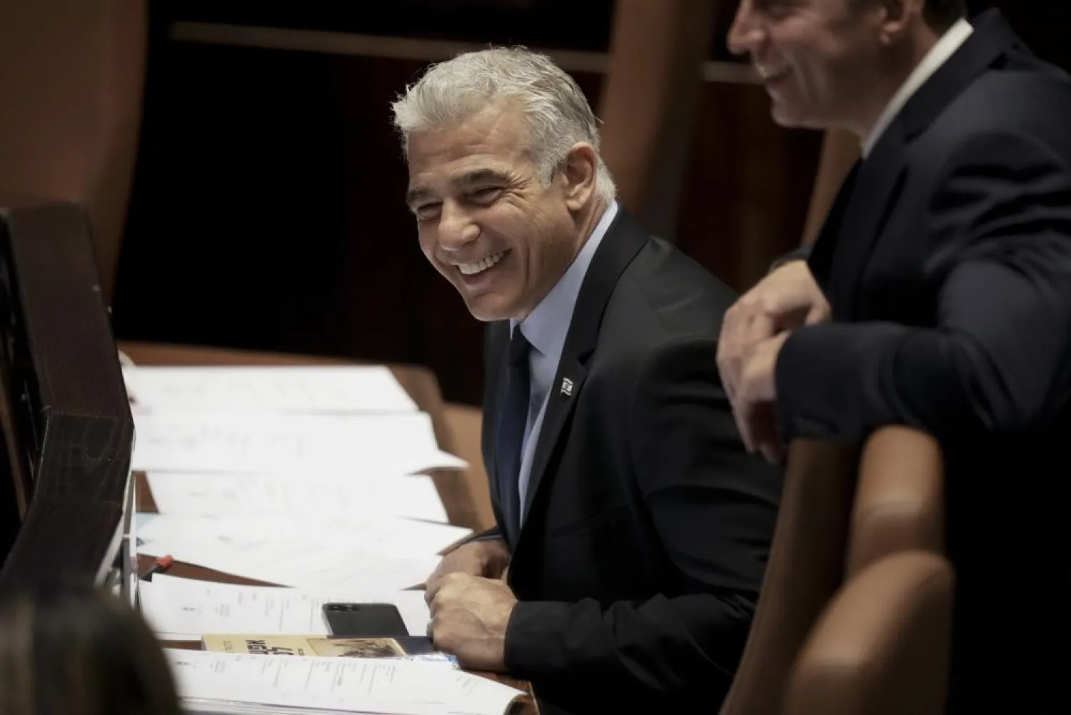 Yair Lapid smiles ahead of the vote on a bill to dissolve parliament, at the Knesset, Israel's parliament, in Jerusalem, Thursday, June 30, 2022. (AP Photo/Ariel Schalit)