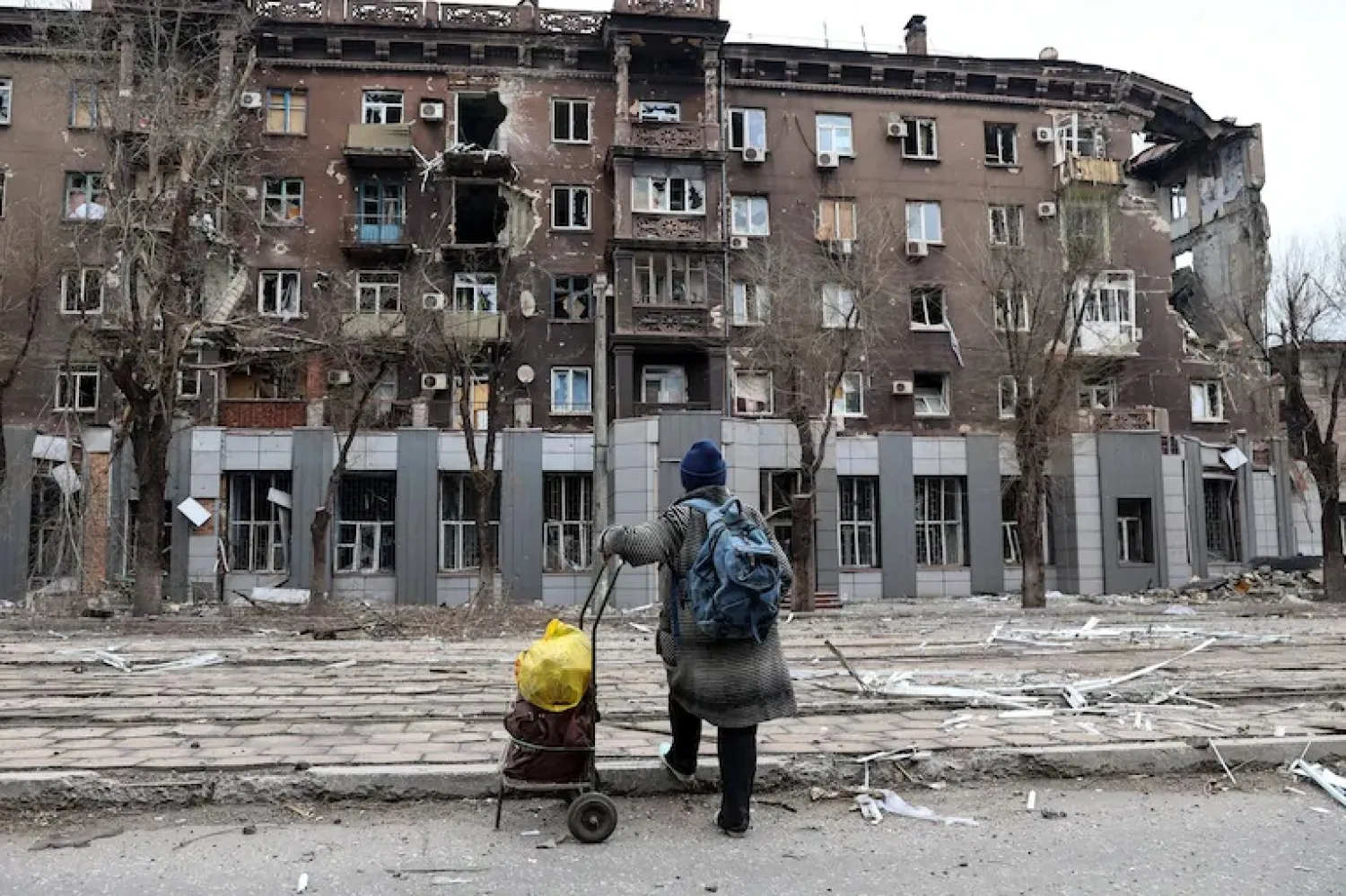 A local resident looks at an apartment building damaged during heavy fighting in Mariupol, Ukraine, on April 16, 2022. (Alexei Alexandrov/AP)