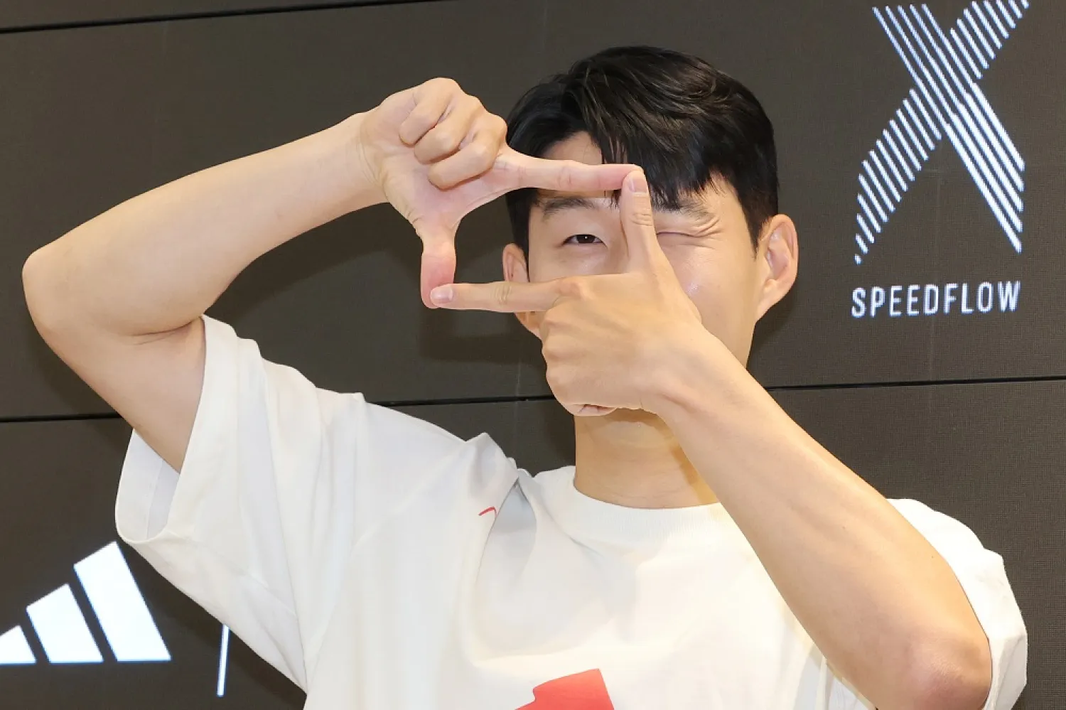 04 July 2022, South Korea, Seoul: Son Heung-min, captain of South Korea's national football team, pretends to take a picture during a publicity event for the German sports brand Adidas. (dpa)