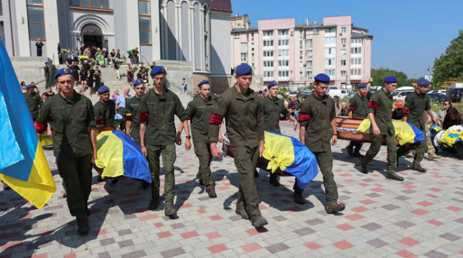 جنود أوكرانيون يحملون نعوش رفاق لهم قتلوا في الحرب مع القوات الروسية خلال مراسم تشييعهم في إيفانو - فرانكيفسك أمس (رويترز)