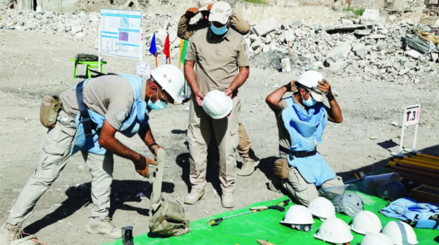 أفراد يقومون أمس بمهمة نزع ألغام زرعها تنظيم «داعش» في الموصل القديمة (رويترز)