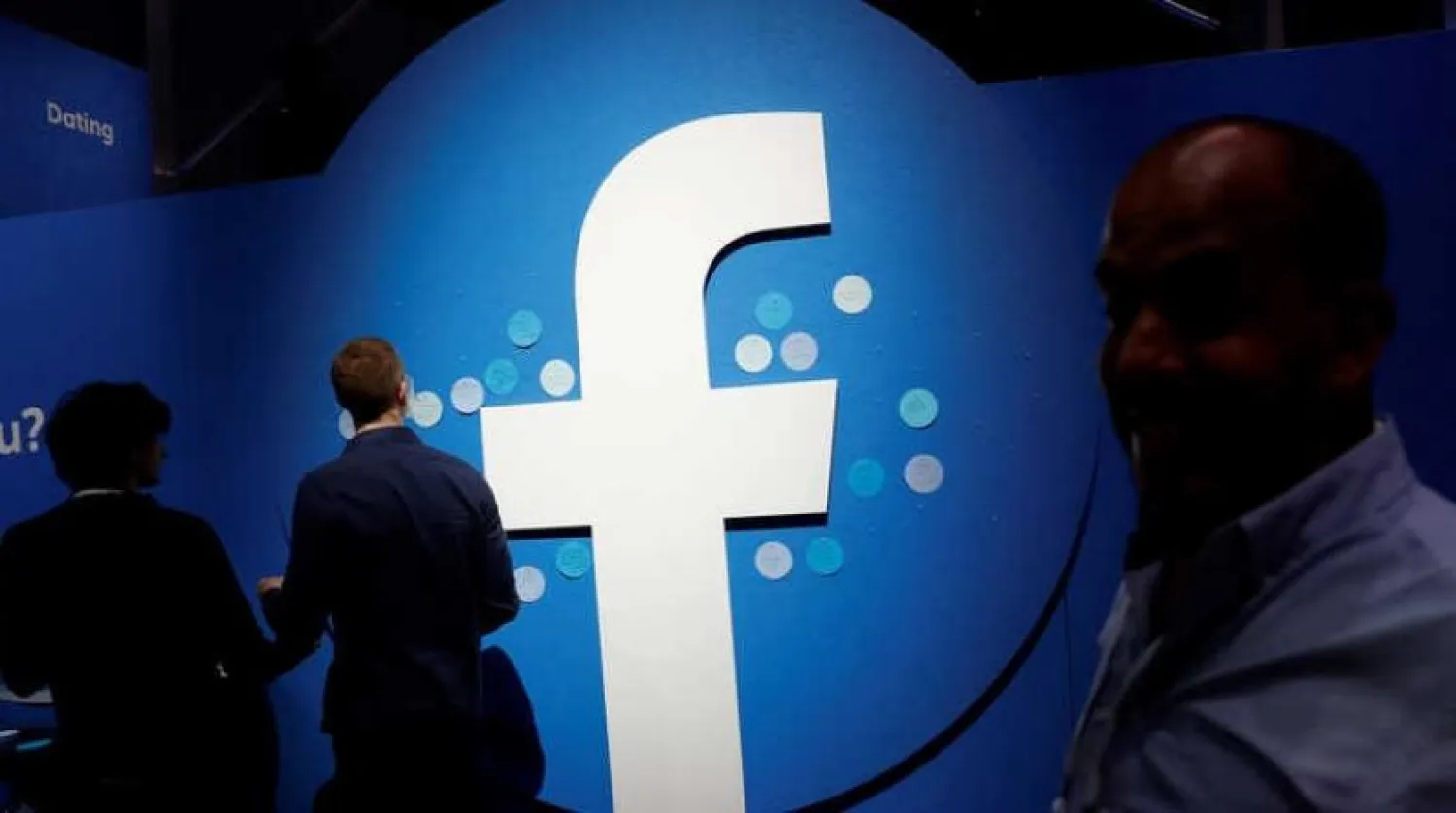 Attendees walk past a Facebook logo during Facebook Inc's F8 developers conference in San Jose, California, US, April 30, 2019. REUTERS/Stephen Lam/File Photo
