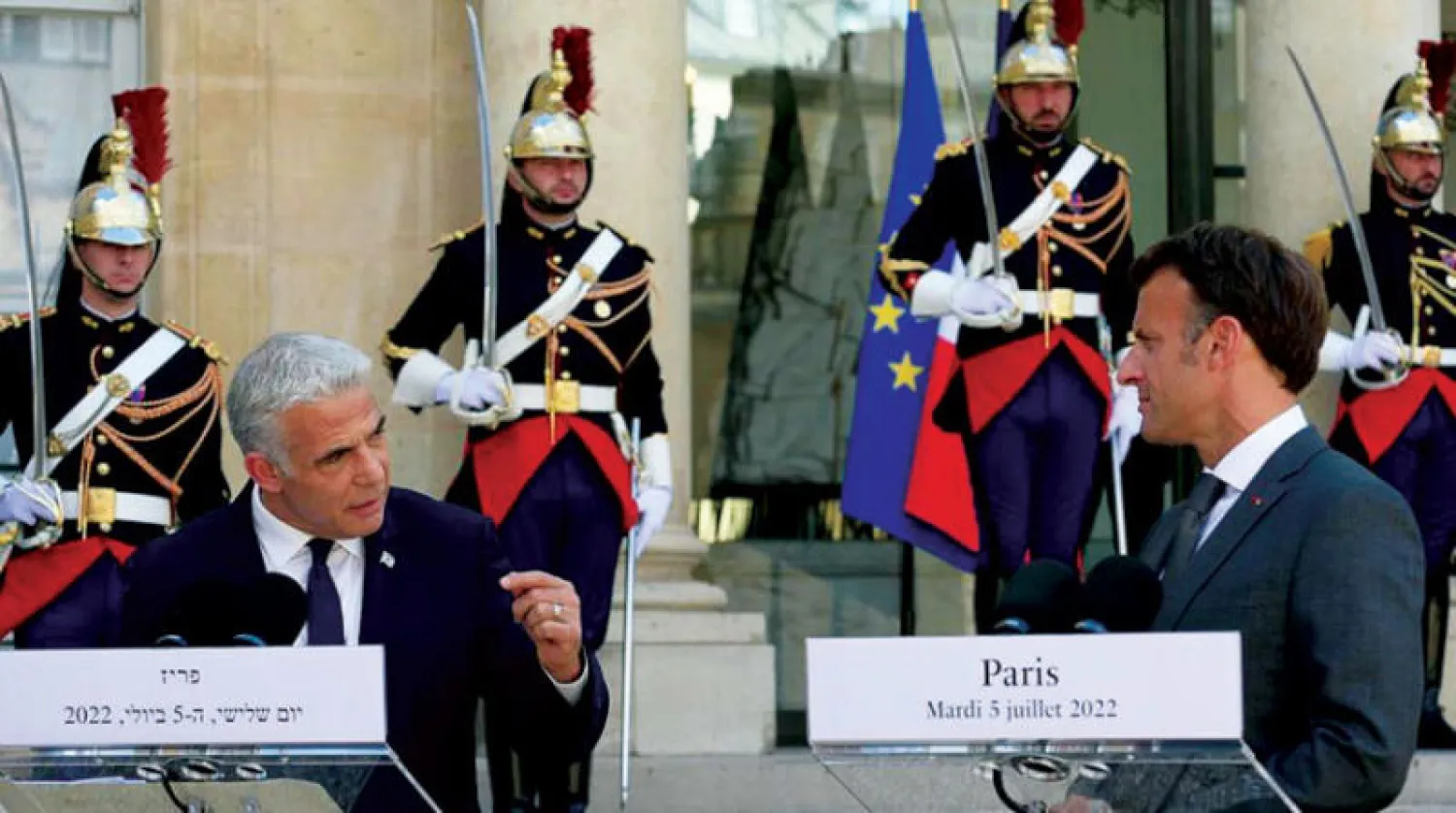 لبيد يخاطب ماكرون في مؤتمر صحافي مشترك في الإليزيه أمس (د.ب.أ)