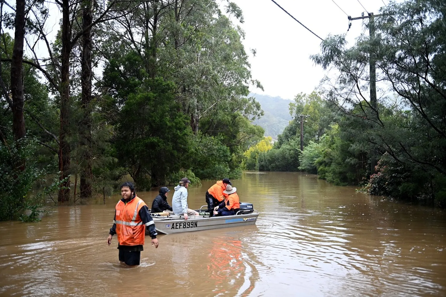 Local residents transport fuel and supplies across the flooded streets on small boats to stranded residents that are cut off by floodwaters which have inundate the town of Yarramalong on the Central Coast, North of Sydney, New South Wales, Australia, 05 July 2022. (EPA)