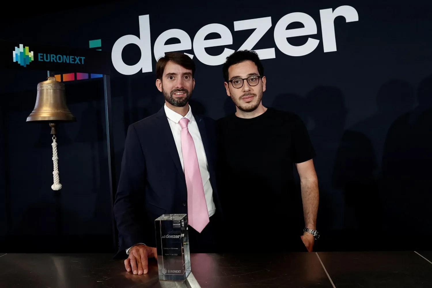 Jeronimo Folgueira, CEO of French music streaming platform Deezer, and Daniel Marhely, co-founder of Deezer, pose during the opening bell ceremony for the company's initial public offering (IPO) on the balcony of the Euronext stock exchange at La Defense business and financial district in Courbevoie near Paris, France, July 5, 2022. (Reuters)