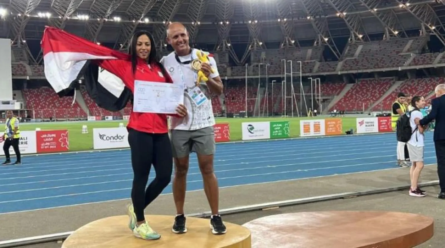 العداءة المصرية بسنت حميدة وزوجها مدربها عقب الفوز بسباق الـ100 متر سيدات بالجزائر (تويتر)