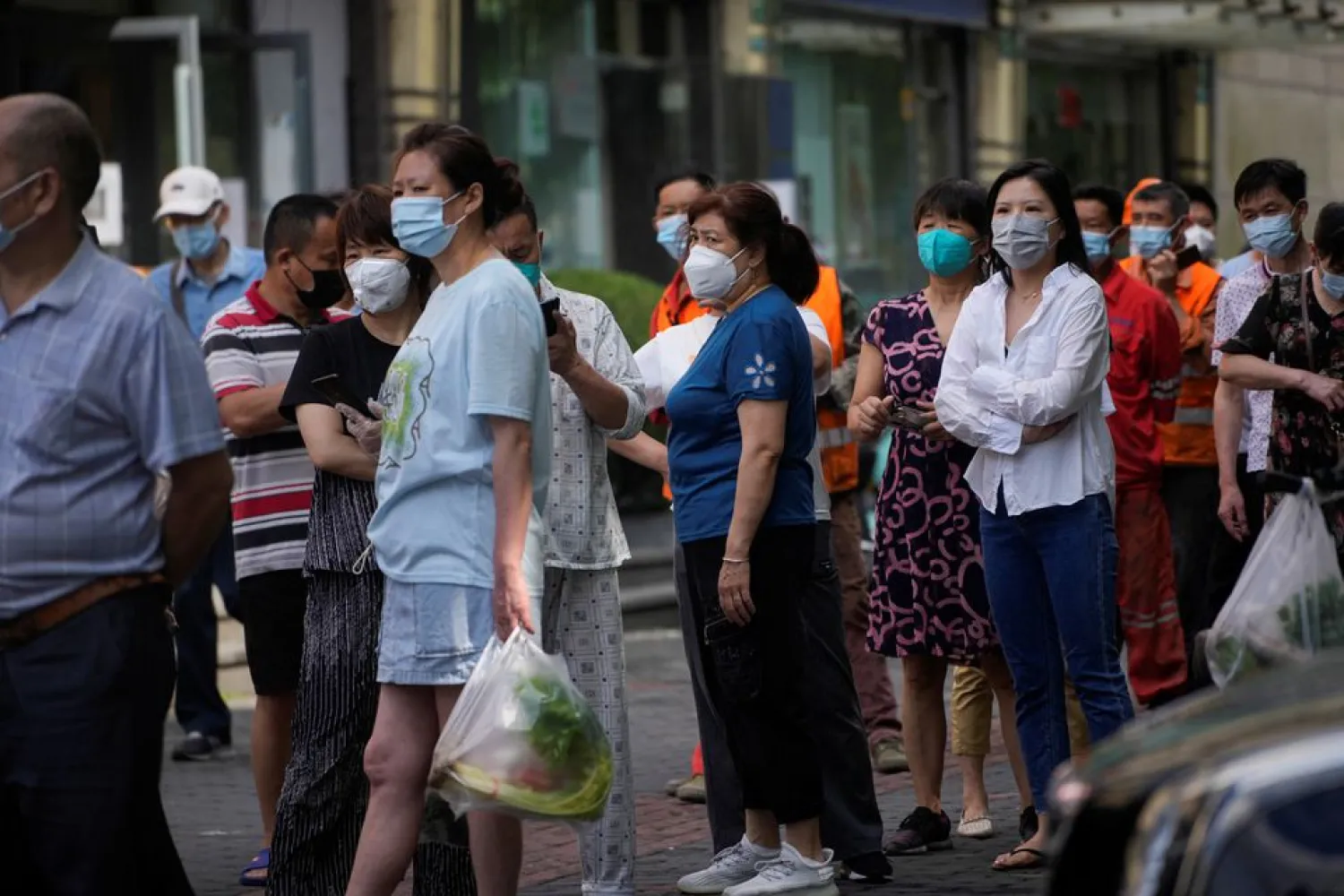 People line up for nucleic acid tests on a street, amid new lockdown measures in parts of the city to curb the coronavirus disease (COVID-19) outbreak in Shanghai, China, June 11, 2022. REUTERS/Aly Song
