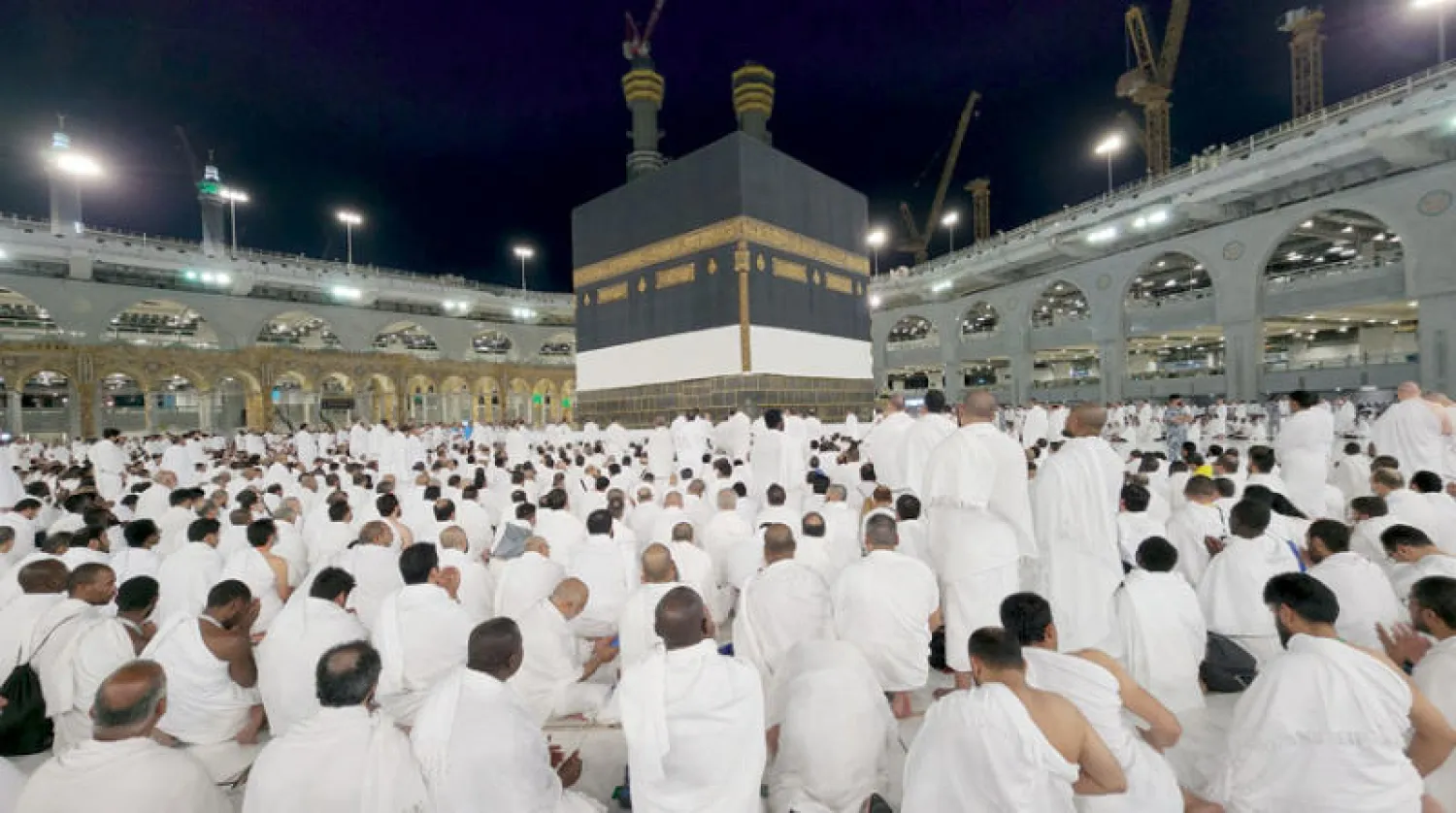 حجاج يؤدون صلاة العشاء في المسجد الحرام أمس (إ.ب.أ)