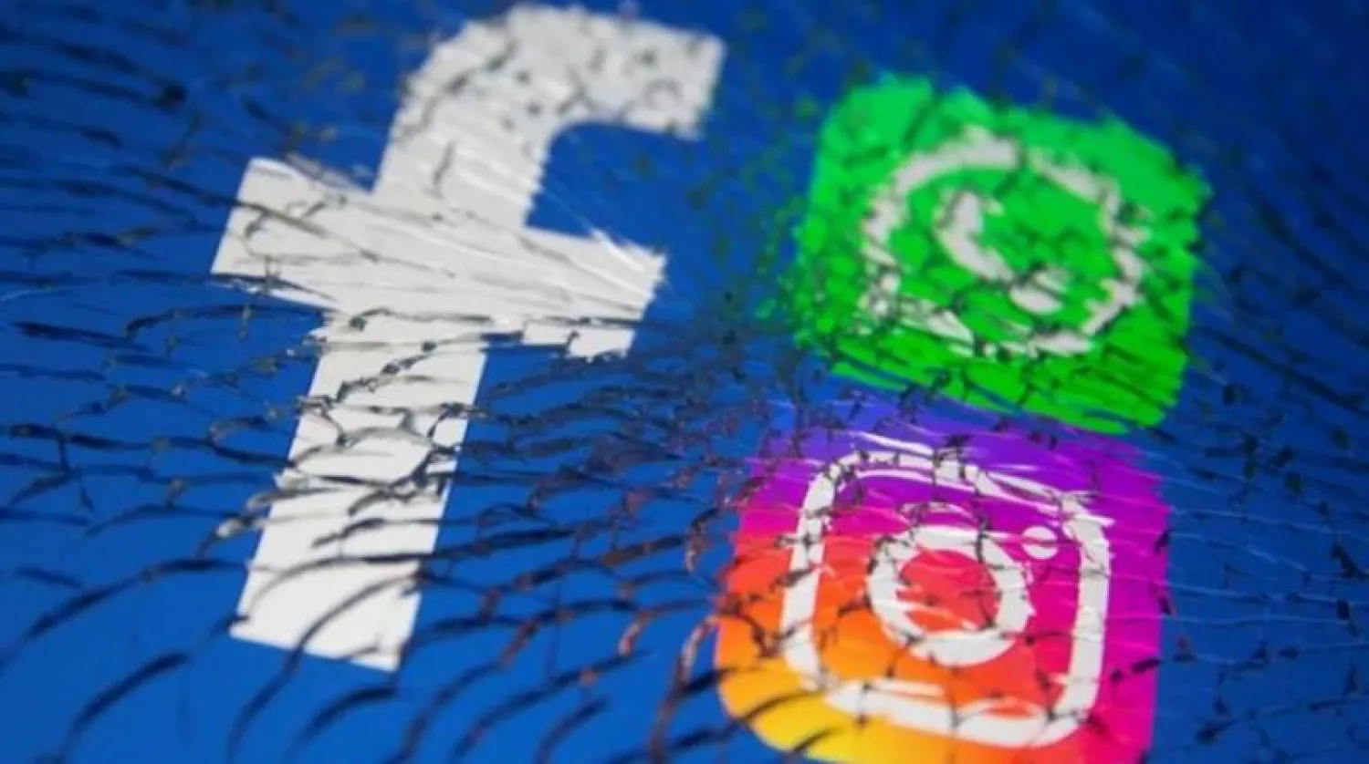 شعار منصة 'فيسبوك' يظهر الى جانب شعاري "إنستغرام' و'واتساب' خلف شاشة محطّمة (أرشيفية)