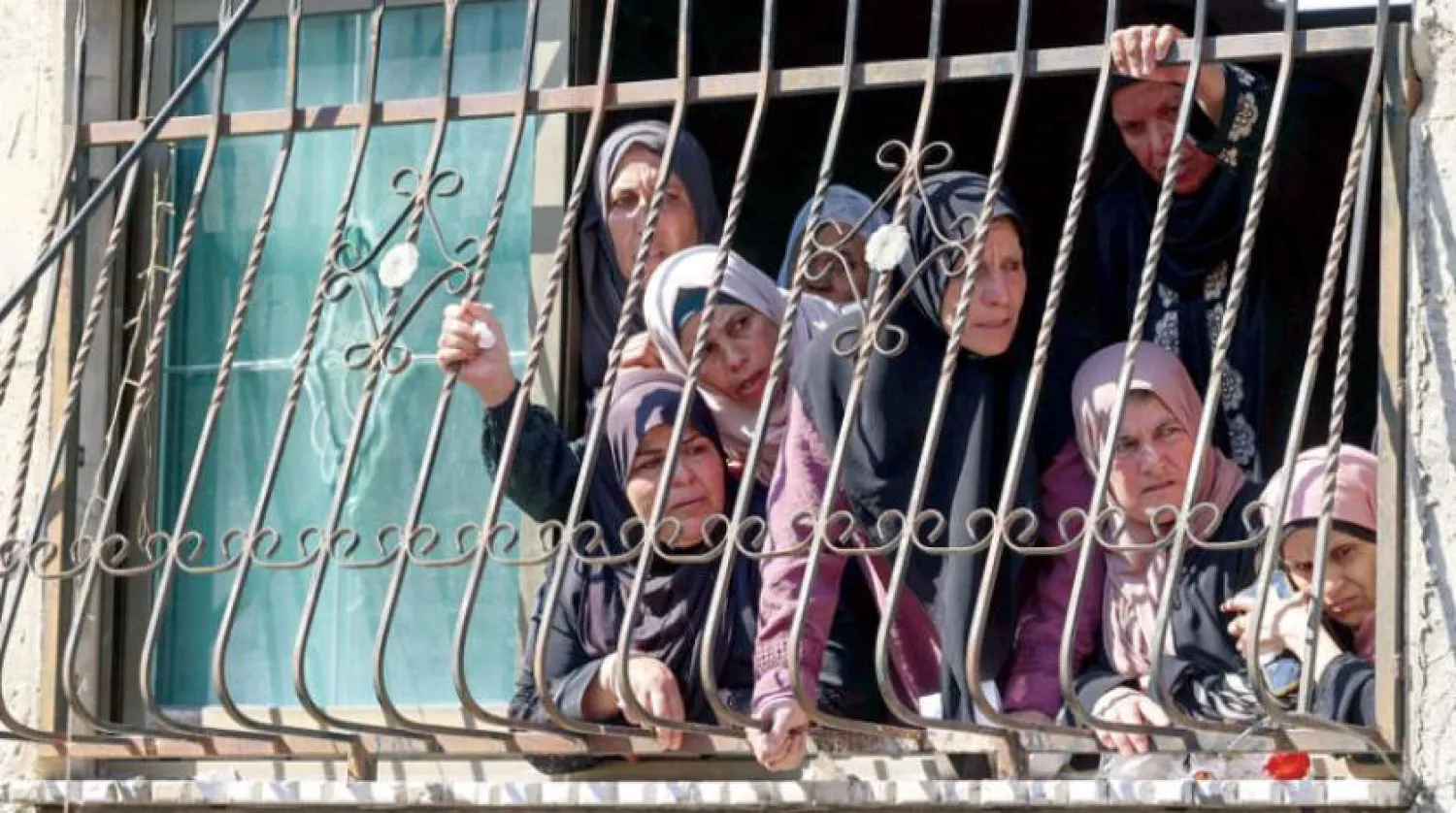 Women on the balcony of a house in the West Bank village of Al-Ja’ba attend the funeral of a Palestinian youth who was shot by Israeli forces on July 3 (Asharq Al-Awsat)