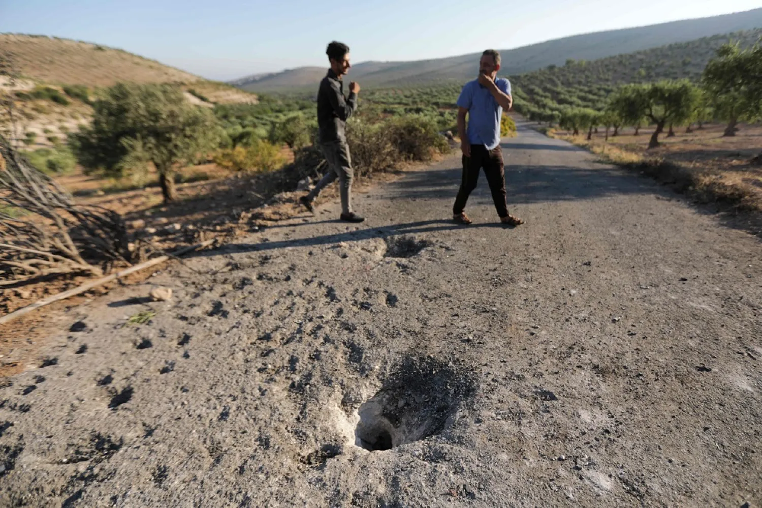 People inspect the site where a US drone targeted killed Maher al-Agal, a leader in the ISIS group, near the village of Khaltan, near Jindires in northern Syria, on July 12, 2022. (AFP)