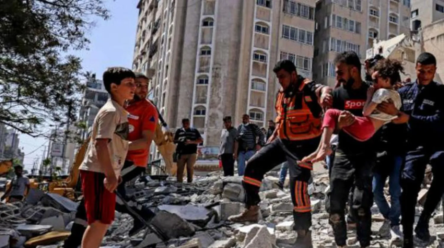 Palestinians pulling a girl out from under the rubble in al-Rimal neighborhood in Gaza in May 2021 following intense Israeli shelling. (AFP)