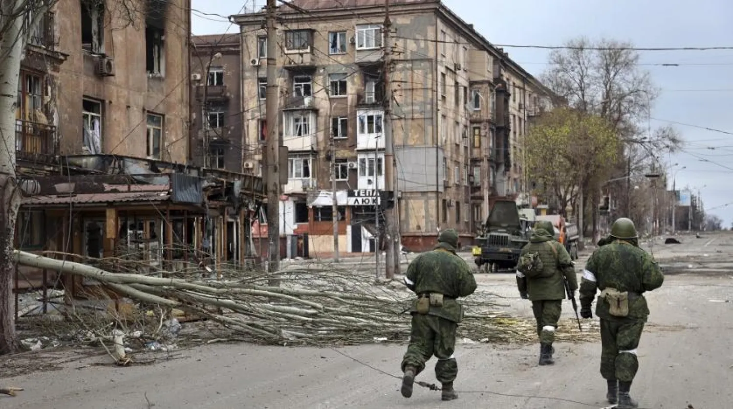 Servicemen from the Donetsk People's Republic walk past damaged apartment buildings near the Illich Iron & Steel Works Metallurgical Plant, the second-largest metallurgical enterprise in Ukraine, in an area controlled by Russian-backed separatist forces in Mariupol, Ukraine, Saturday, April 16, 2022. (AP)
