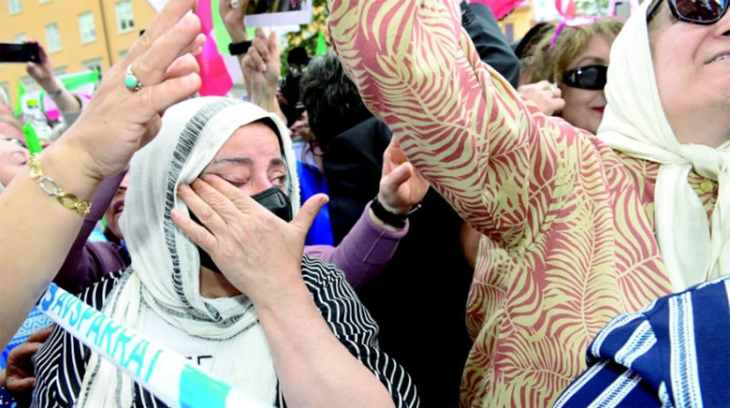 إيرانية تبكي في تجمع للمعارضين أمام المحكمة بعد النطق بالحكم على نوري (رويترز)