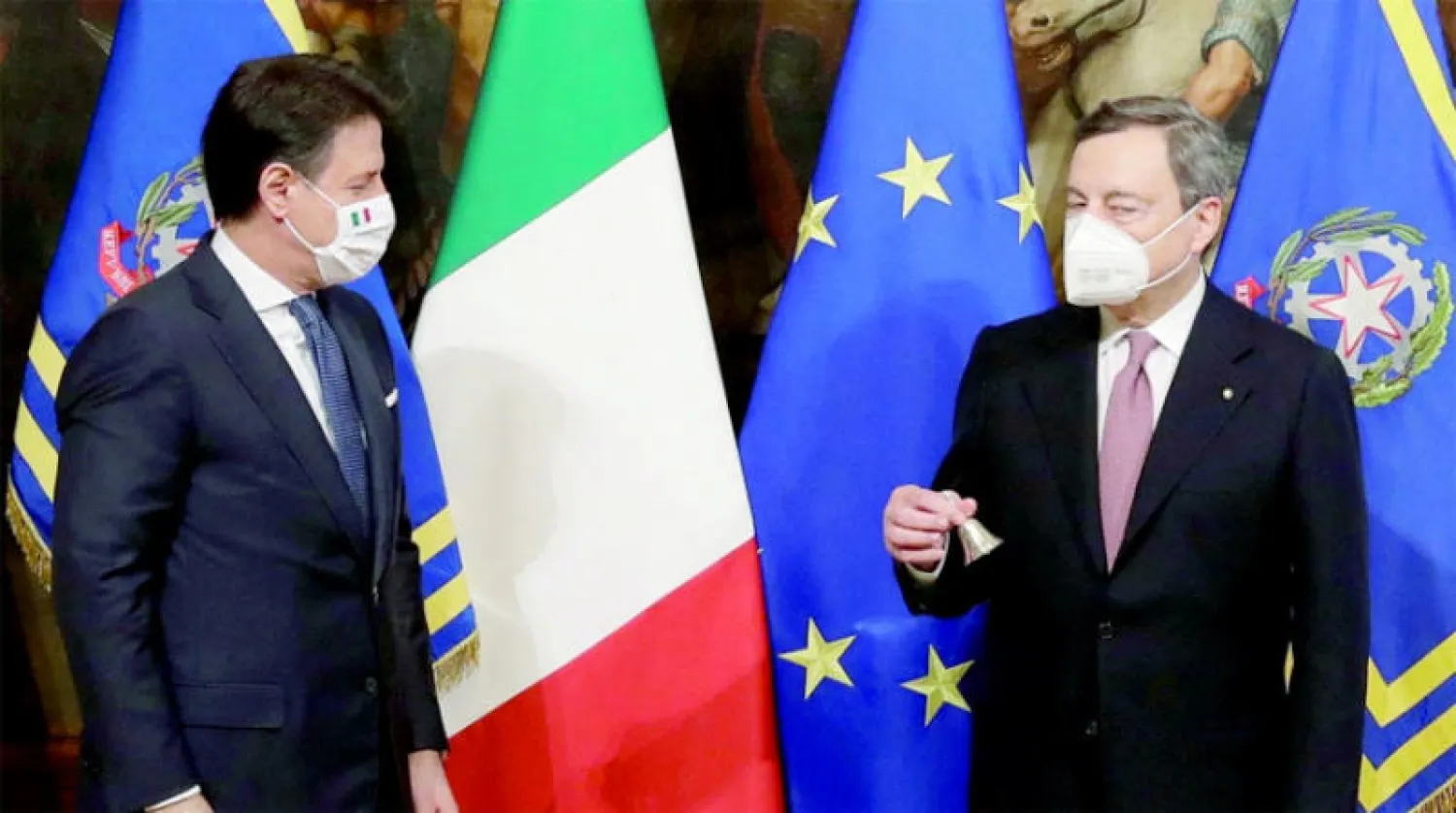 دراغي يمسك جرس مجلس الوزراء بعد التسليم والتسلم مع سلفه جوسيبي كونتي في 13 فبراير 2021 (رويترز)