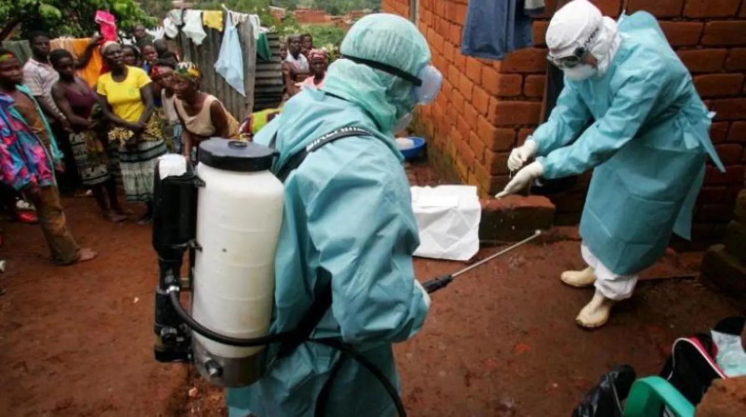 2005 yılında Angola'daki salgın sırasında bir Marburg virüsü hastasının evinin dışındaki sağlık görevlileri (Reuters)
