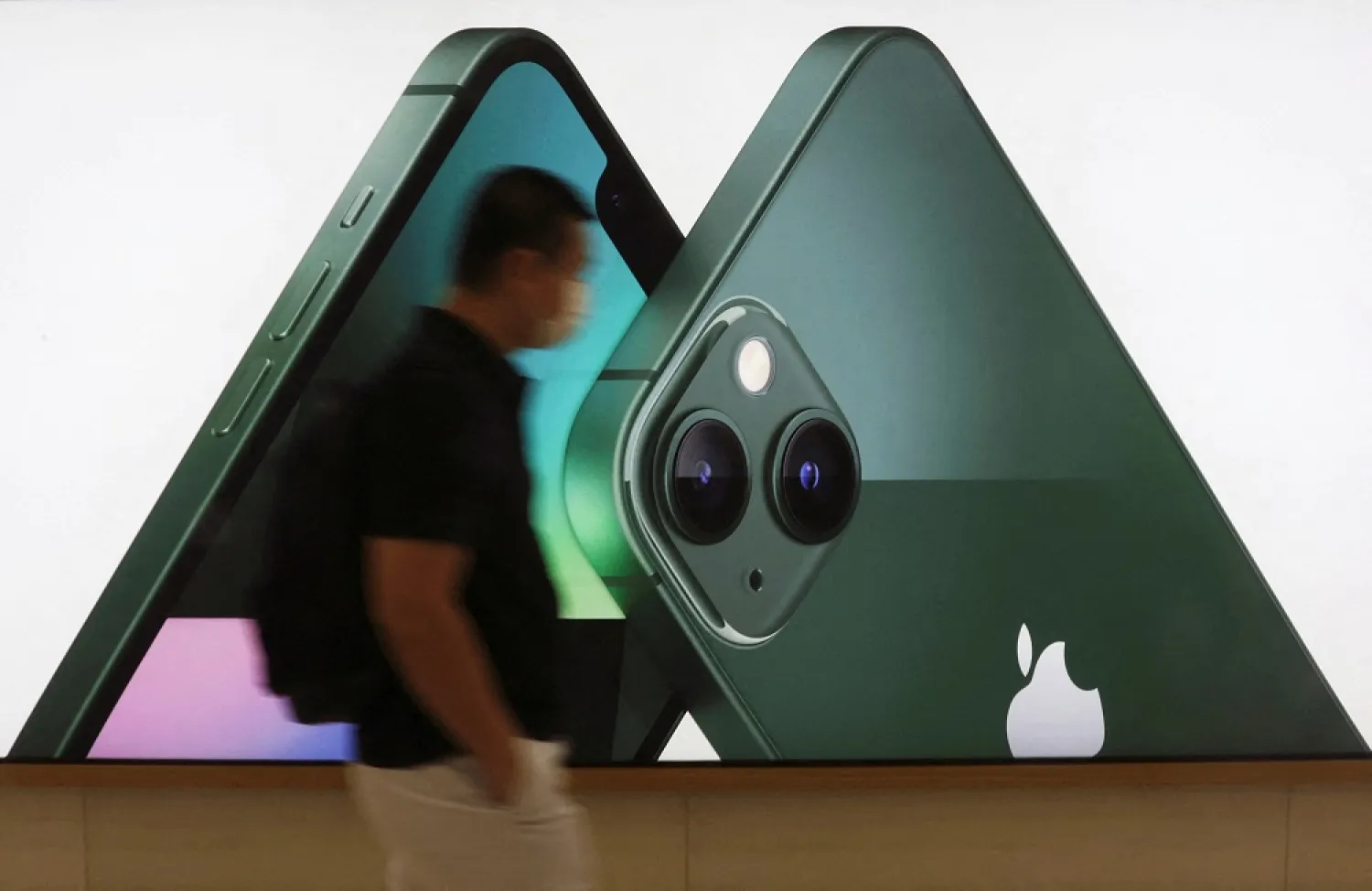 A customer passes an Apple iPhone 13 advertisement at an Apple shop in Singapore March 18, 2022. (Reuters)