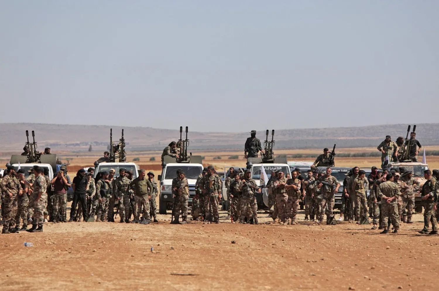 Turkey-backed Syrian fighters gather along the frontlines opposite Kurdish forces near the town of Dadat north of Manbij in Syria's northern Aleppo province, on July 5, 2022. (AFP)