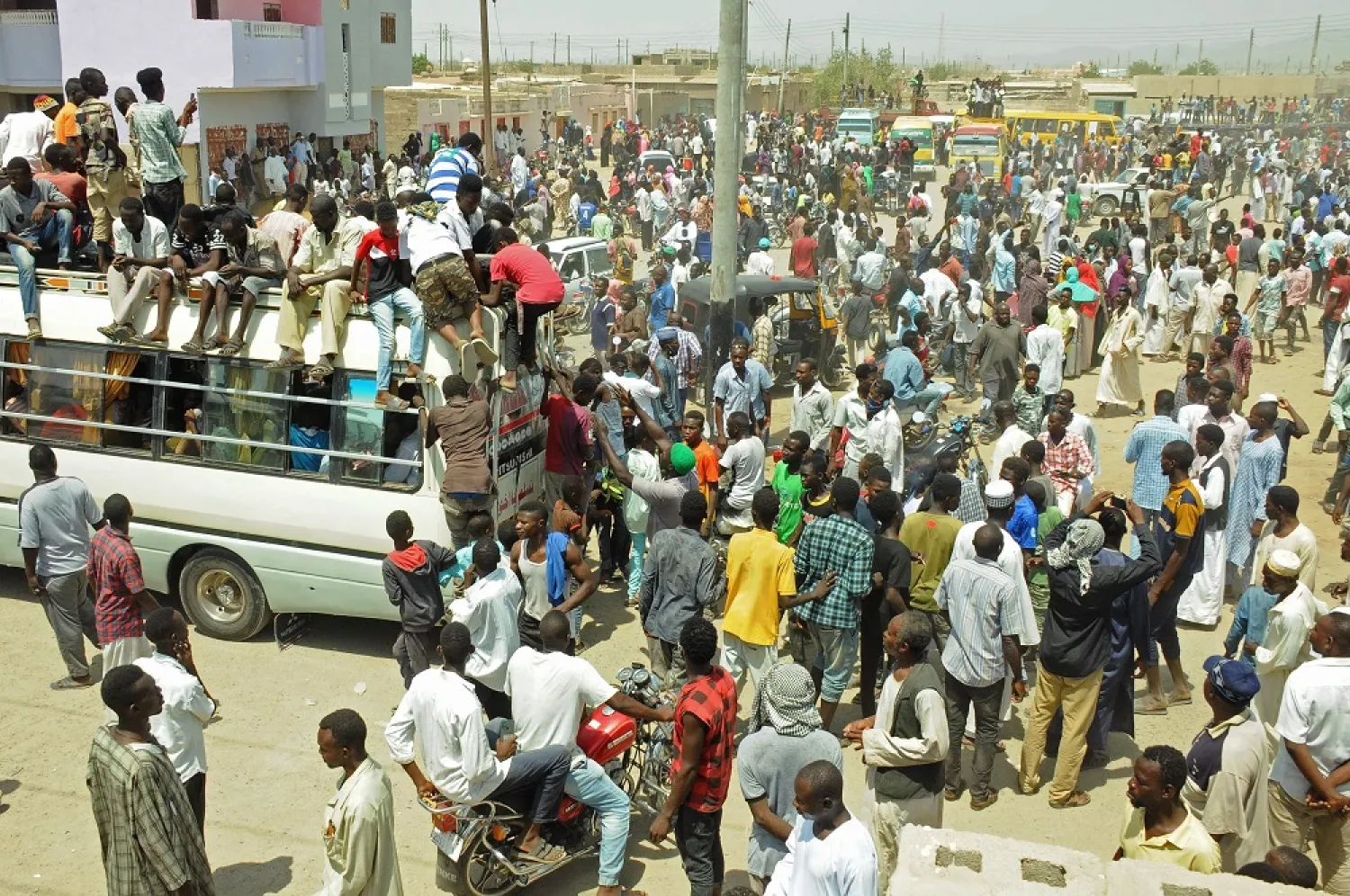 Scores of Hausa people gather outside local government offices in Port Sudan, on the Red Sea, on July 19, 2022 to demand justice for comrades killed in a deadly land dispute with a rival ethnic group in the country's south. (AFP)