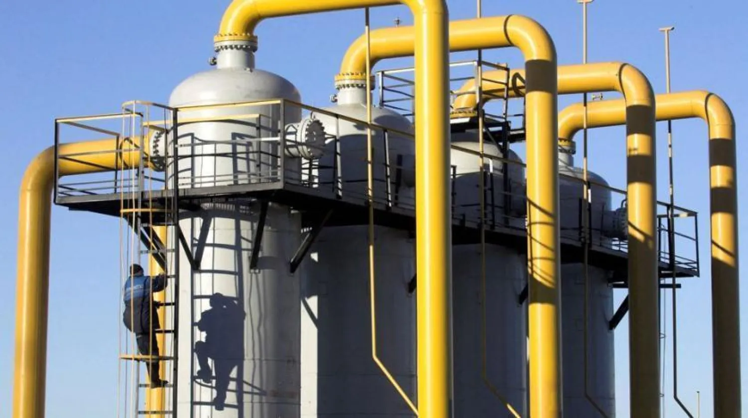 A worker climbs a cylinder at a gas compressor station at the Yamal-Europe pipeline near Nesvizh, southwest of Minsk December 29, 2006. REUTERS/Vasily Fedosenko (BELARUS)/File Photo
