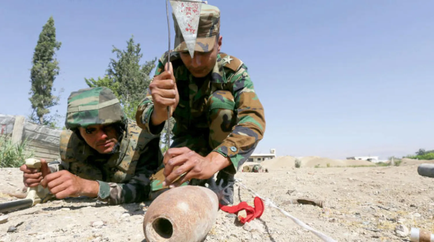 جنديان سوريان خلال تدريب على إزالة الألغام قرب دمشق في 19 يونيو الماضي (أ.ف.ب)