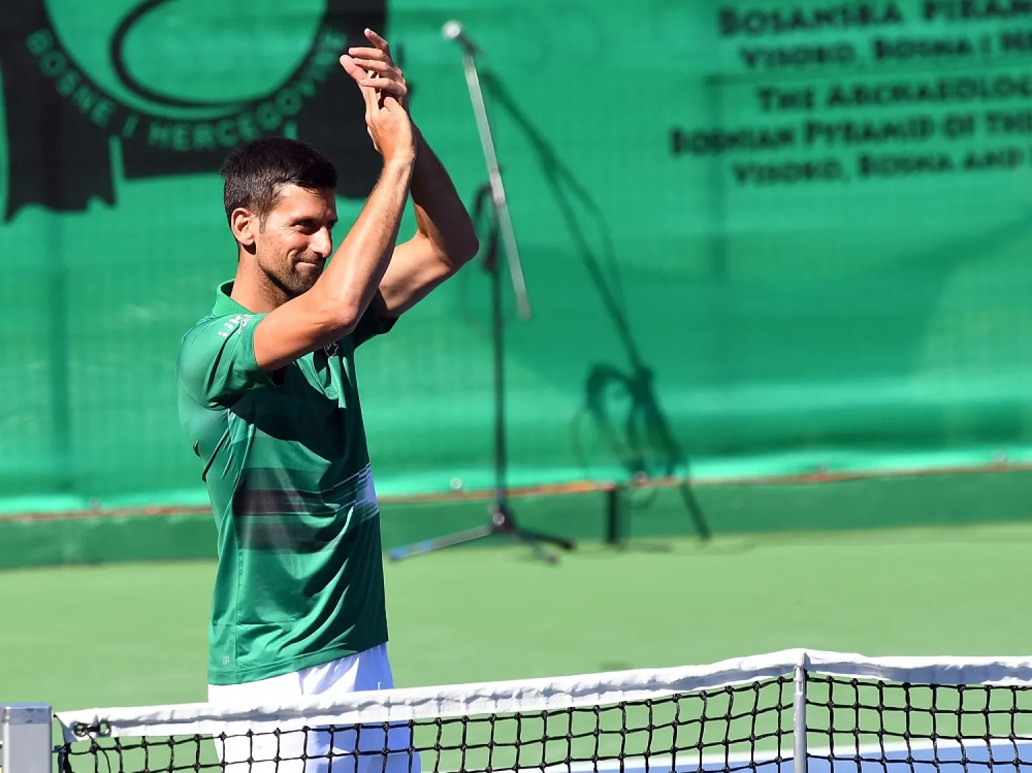 Serbian tennis player Novak Djokovic greets the audience during an exhibition match, organized to mark the opening of a tennis court at the "Archaeological park of the Bosnian pyramid" near Visoko, north of Sarajevo, on July 13, 2022. (AFP)