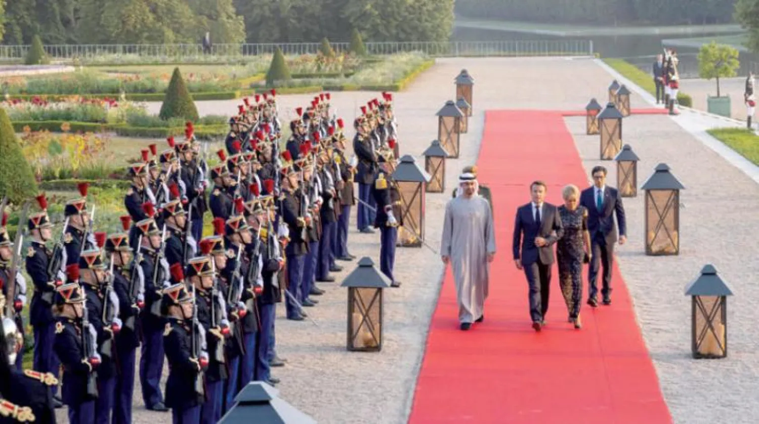 Şeyh Muhammed bin Zayed Al Nahyan, Fransa Cumhurbaşkanı ve eşiyle önceki gün Versay'daki Grand Trianon'daki akşam yemeğine giderken (AFP)