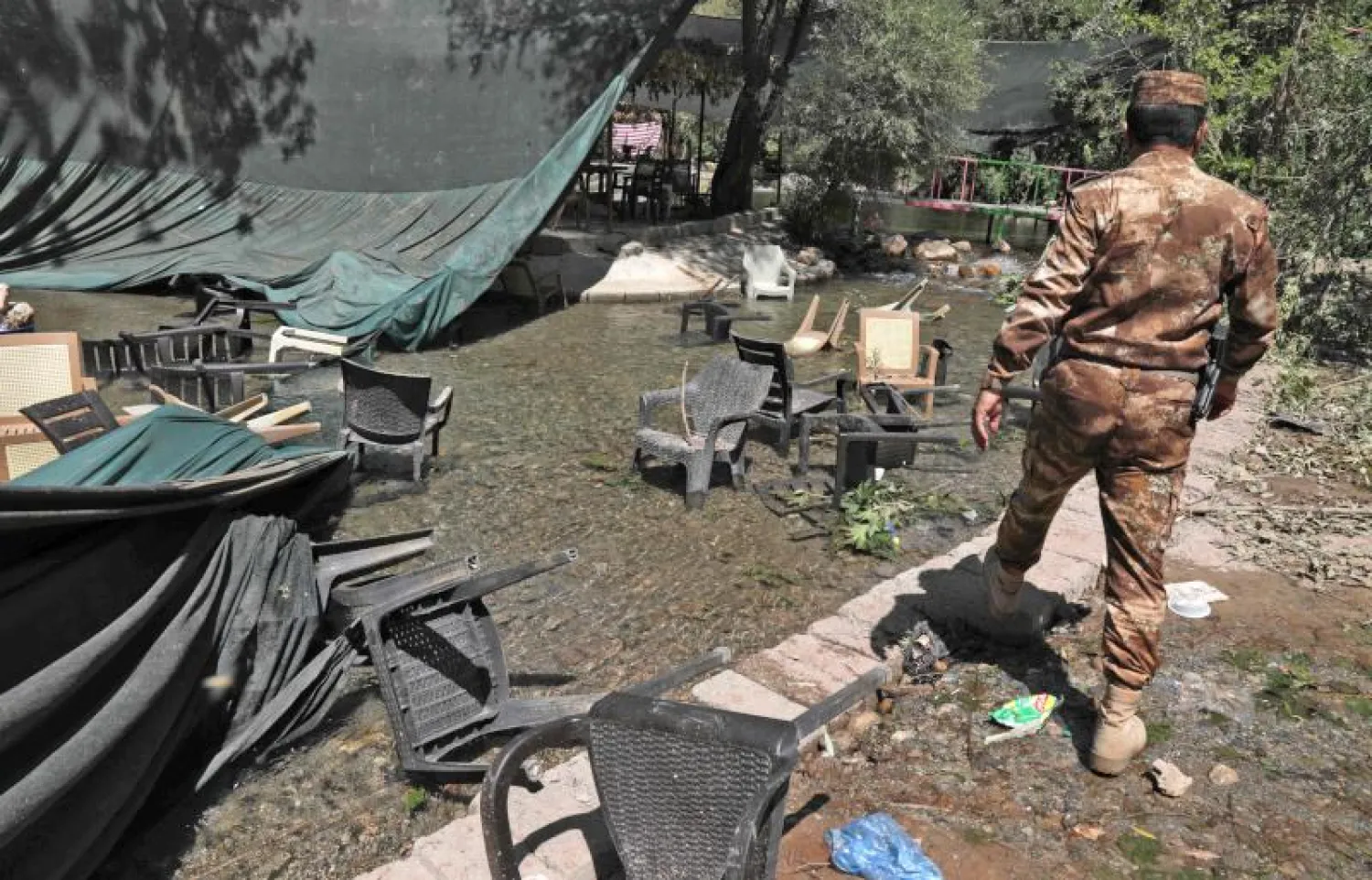 فرد أمن عراقي يتفقد آثار القصف في قضاء زاخو شمال إقليم كردستان (أ.ف.ب)