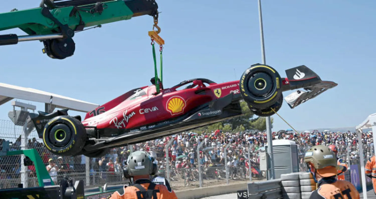 سيارة فيراري تُحمل خارج الحلبة الفرنسية بعد خطأ السائق لوكلير واصطدامه بحاجز الأمان (أ.ف.ب)