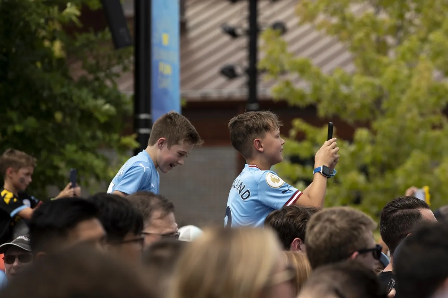 Young fans take photos of Manchester City's Premier League trophy before an exhibition soccer match against German Bundesliga champions FC Bayern Munich, Saturday, July 23, 2022, at Titletown in Ashwaubenon, Wis. (AP)