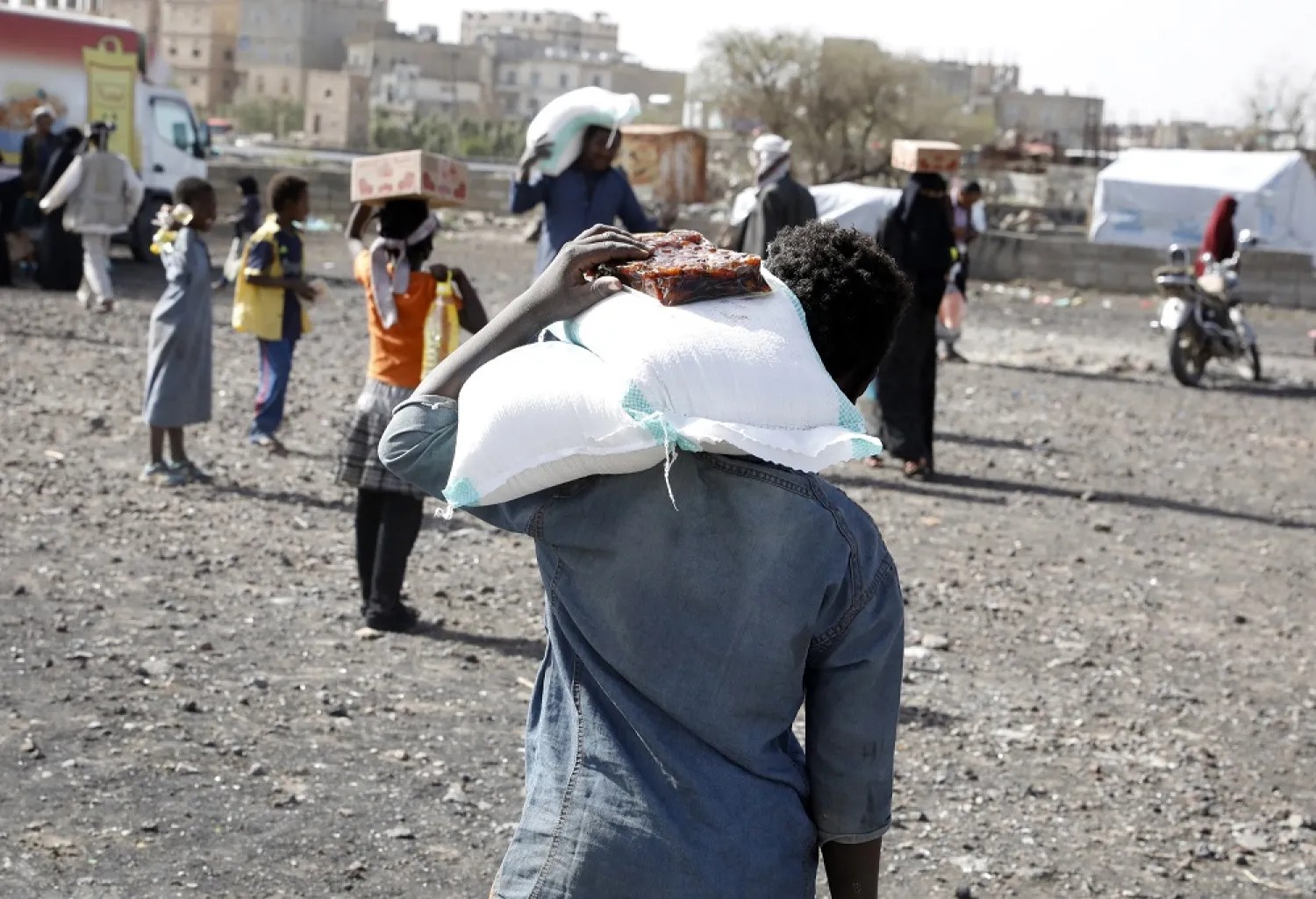 Displaced Yemenis receive food aid amid a heightened food insecurity, at a camp for Internally Displaced Persons (IDPs) on the outskirts of Sanaa, Yemen, 29 April 2022 (issued 27 June 2022). (EPA)