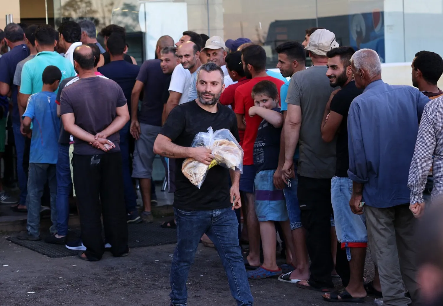 Lebanese line up in front of a bakery in the Safra highway north of Beirut on July 26, 2022. (AFP)