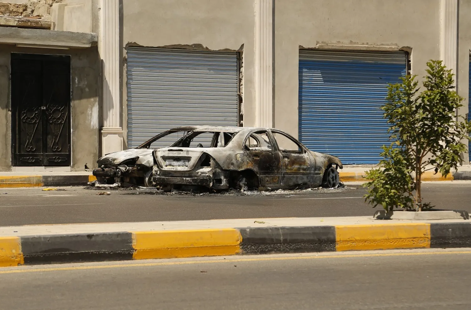 The remains of a car damaged in clashes stands in a street in the Libyan capital of Tripoli on Friday, July 22 2022. (AP)