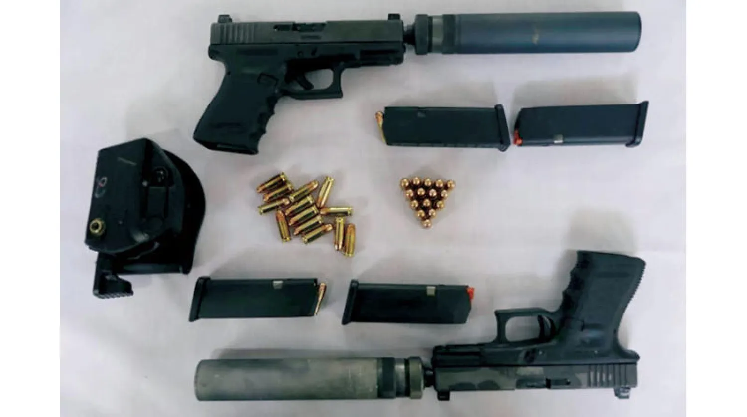 أسلحة معروضة في مكان مجهول بإيران تدعي وزارة الأمن الإيرانية أنها صادرتها من عملاء مرتبطين بـ«الموساد» الإسرائيلي (أ.ف.ب)