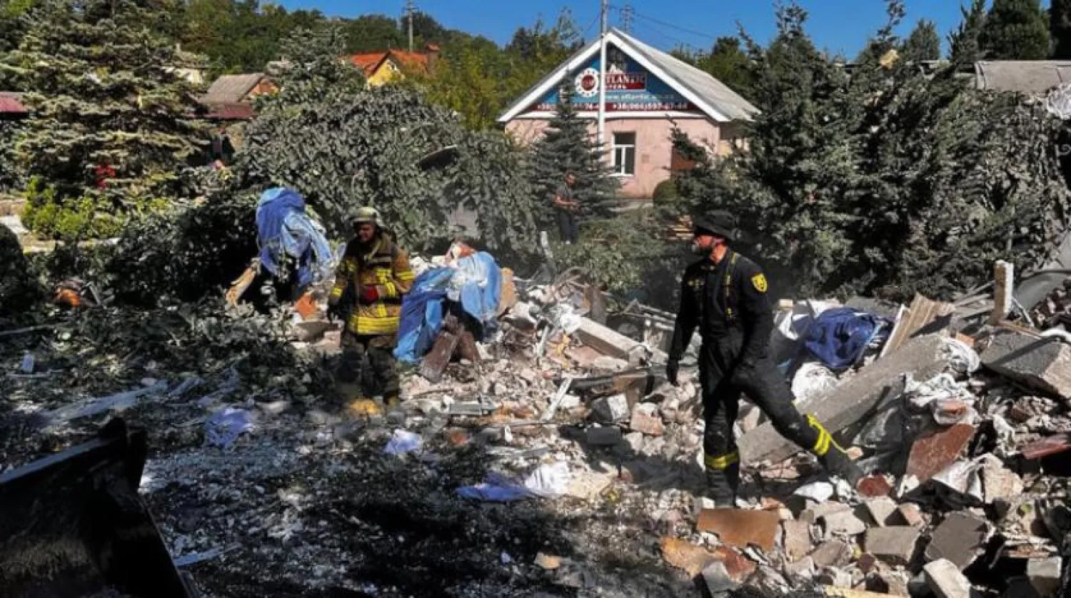 Kurtarma ekipleri, Donetsk bölgesinde füze saldırısı sonucu yıkılan bir binanın enkazını inceliyor (AFP)