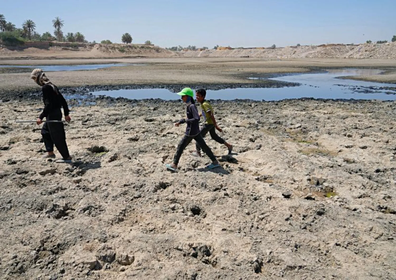 عراقيون يعبرون أمام نهر ديالى الذي تراجع منسوبه بشكل كبير (أ.ب)