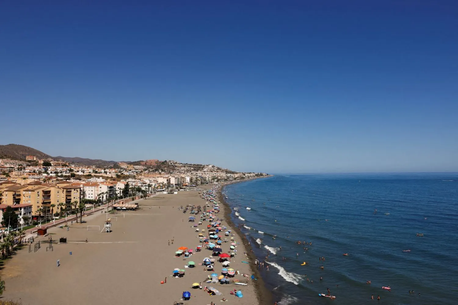 People cool off at the Mediterranean Sea on a beach on a hot summer day in Rincon de la Victoria, near Malaga, Spain, July 9, 2022. REUTERS/Jon Nazca

