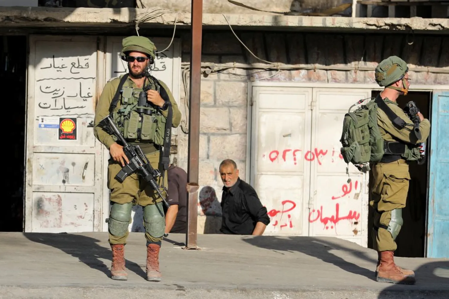 Israeli soldiers stand while stationed outside a Palestinian shop in Huwara, Israeli-occupied West Bank, May 26, 2022. REUTERS/Raneen Sawafta