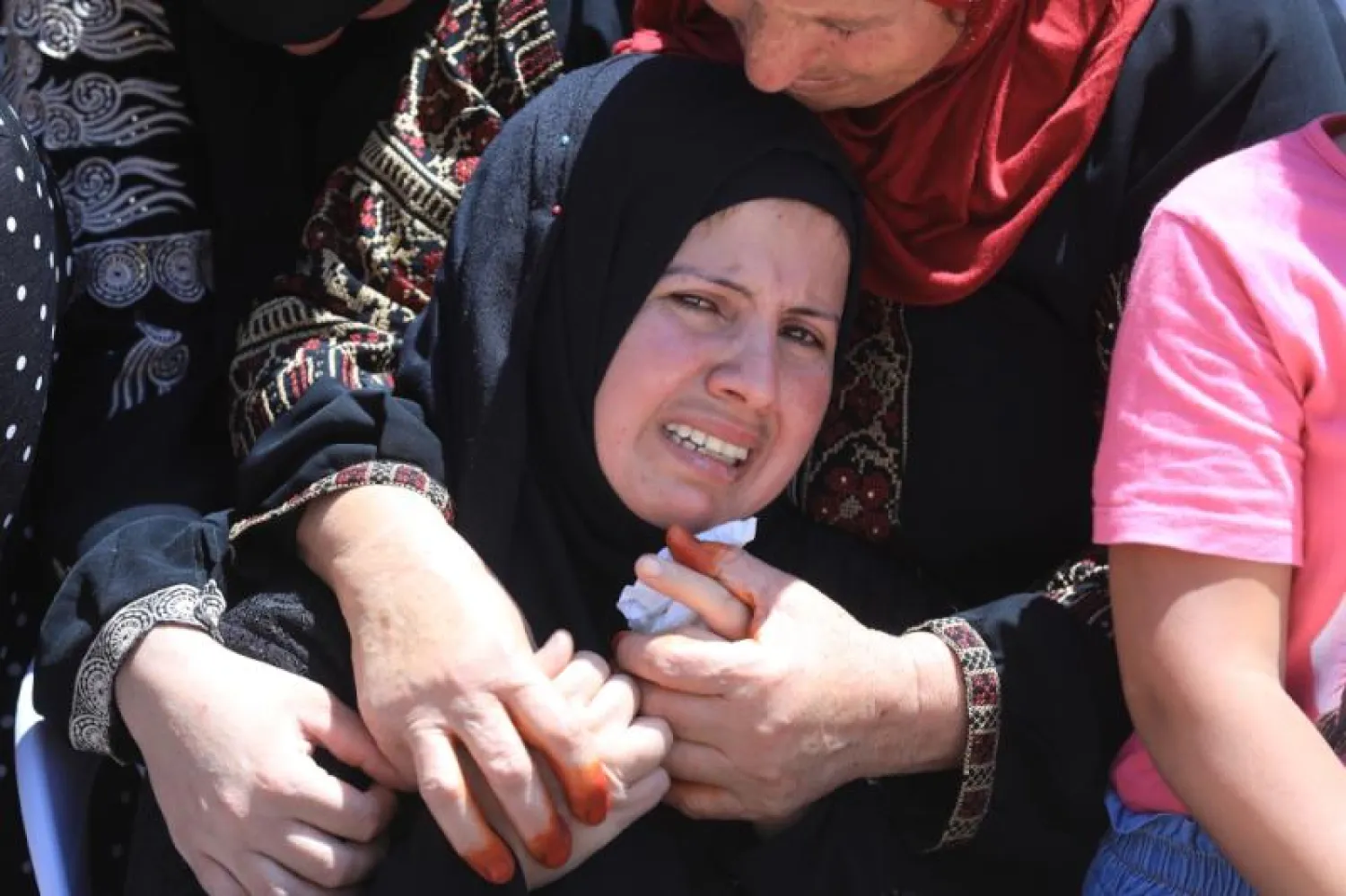 ملامح الحزن والأسى لدى أقارب الفتى القتيل أمجد أبو عليا (16 عاماً) خلال تشييع جنازته في بلدة المغير شمال رام الله أمس (إ.ب.أ)